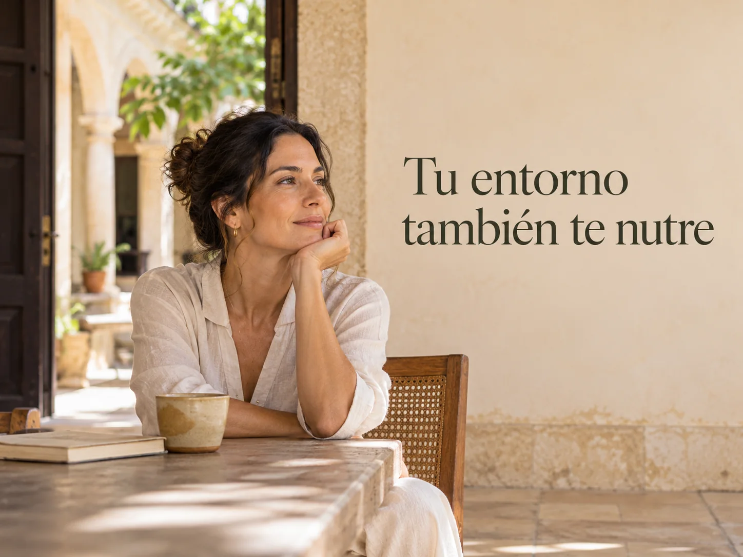 Mujer sentada en un corredor de casa yucateca con una taza, junto al texto: tu entorno también te nutre
